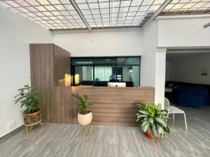 an office with two potted plants in a room at Outlanders House BOG Airport in Bogotá
