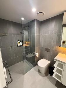 a bathroom with a shower with a toilet and a sink at 2B-1BR-1Car-Courtyard-CBD-Shops in Canberra