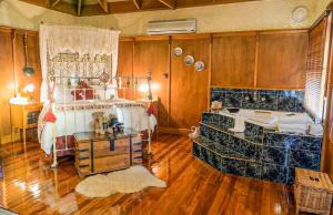 una camera da letto con un letto e una vasca da bagno di StayAU Ironbark Cottage Romantic Retreat Dandenong a Mount Dandenong