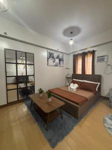 a living room with a large bed and a table at Balauro's Haven in Trece Martires +11 photos