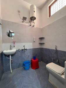 a bathroom with a sink and a toilet at Happy Inn in Faizābād +4 photos