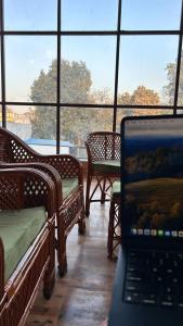 a laptop computer sitting in a room with windows at Happy Inn in Faizābād