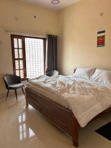 a bedroom with a bed and a chair and a window at Happy Inn in Faizābād