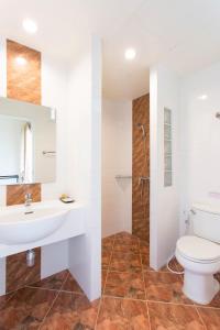 a bathroom with a toilet and a sink and a shower at โรงแรมธาราคีรีเพลส in Ban Pang Kae