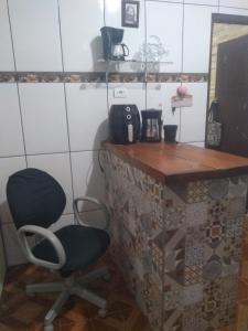 ein Zimmer mit einem Schreibtisch und einem Stuhl in der Unterkunft Kitnet centro São thome hostel in São Thomé das Letras + 4 Fotos
