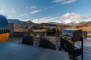 a grill on a deck with mountains in the background at MIRISE Sky Villa & Sauna in Minakami