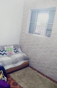 ein Bett in einem Zimmer mit Fenster in der Unterkunft Kitnet centro São thome hostel in São Thomé das Letras