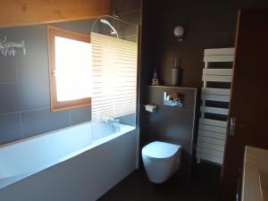 a bathroom with a tub and a toilet and a window at Chalet spacieux au soleil près des pistes, idéal pour 9 personnes - FR-1-445-219 in Montgenèvre