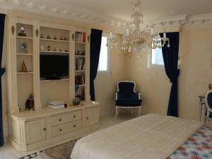 a bedroom with a bed and a tv and a chair at Villa de Maître 6 Chambres avec Piscine et Jacuzzi - FR-1-768-119 in Roquebrune-sur-Argens