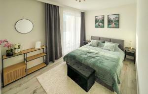 a bedroom with a green bed and a window at Stunning Home In Kamien Pomorski in Kamień Pomorski