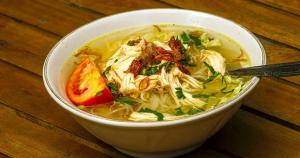 a bowl of noodle soup on a wooden table at D sabin cottage in Punten