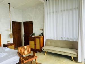 a bedroom with a bed and a couch and a chair at Villa Joy Ella in Ella