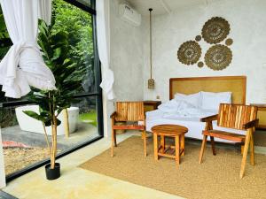 a bedroom with a bed and a table and chairs at Villa Joy Ella in Ella
