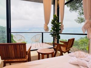 a bedroom with a bed and a view of the ocean at Villa Joy Ella in Ella