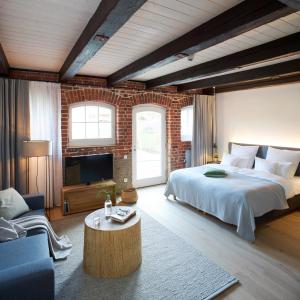 una camera con un grande letto e un muro di mattoni di meinwolfsburg hotel auf dem rittergut vormals Yard Boarding Hotel a Wolfsburg