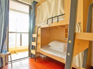 Voodi või voodid majutusasutuse Yiweidu Youth Apartment toas
