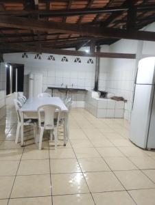 a kitchen with a white table and white chairs at Chacara para Aluguel Recanto Eco vida Cuiaba in Cuiabá