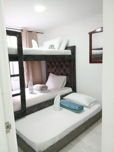 two bunk beds in a white room with a blue tray at Vacaciones por el eje cafetero in Circasia