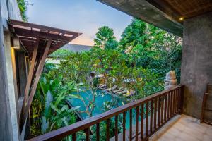 a balcony of a resort with a view of a pool at Purana Suite Ubud in Ubud