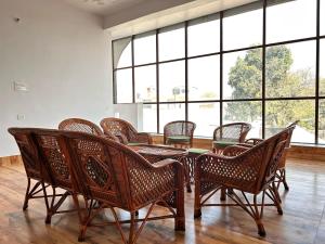 a room with a table and chairs and windows at Happy Inn in Faizābād