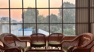 a group of chairs sitting in front of a large window at Happy Inn in Faizābād