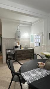 a kitchen with a table and chairs and a table and a stove at Departamento familiar cerca del aeropuerto in Ezeiza