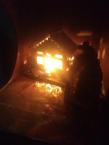 eine Person, die im Dunkeln vor einem Haus steht in der Unterkunft Kitnet centro São thome hostel in São Thomé das Letras