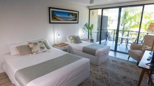 a hotel room with two beds and a balcony at Agnes Water Beach Club in Agnes Water +100 photos