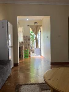 a living room with a table and a room with a doorway at 'La Maison' 2 bedroom house in Arusha in Arusha
