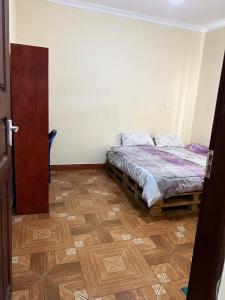 a bedroom with a bed and a wooden floor at 'La Maison' 2 bedroom house in Arusha in Arusha