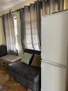 a living room with a couch and a refrigerator at 'La Maison' 2 bedroom house in Arusha in Arusha