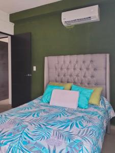 Un dormitorio con una cama con una computadora portátil encima. en Departamento Zona Diamante, en Barra Vieja 27 fotos más