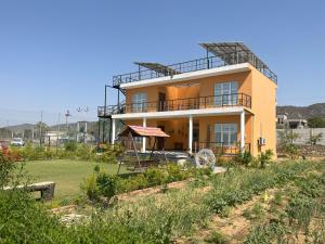 a yellow house with a gazebo in a yard at Aranyavas Nature Retreat, Jaipur in Jaipur