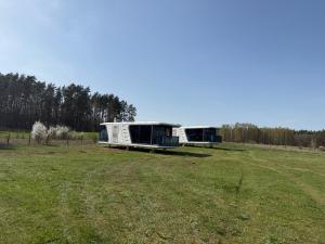 two trailers sitting in a field of grass at Eco domki Mazury in Ruciane-Nida