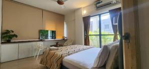 a bedroom with a bed and a large window at La vaccanza Suite -403 in Pune