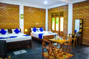 a bedroom with two beds and a table and chairs at Sigiriya Dream Inn in Sigiriya +72 photos