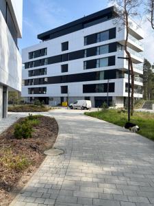 un chien est allongé sur un trottoir devant un bâtiment dans l'établissement Apartament Słoneczny AKTENA Shellter Rogowo, à Rogowo