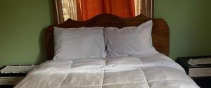 a bed with white sheets and pillows in a bedroom at Seaview Guesthouse Apt#1 in Bank Level