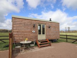 a tiny house with a table and chairs at Balwen Shepherd's Hut in Montgomery