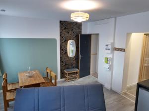 a kitchen and dining room with a blue couch and a table at Appartement lumineux de ville avec 2 places de parking privées intérieur in Beuvrages