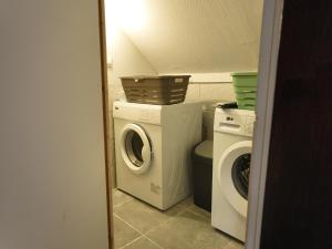 a bathroom with a washing machine and a washer at Appartement lumineux de ville avec 2 places de parking privées intérieur in Beuvrages +4 photos