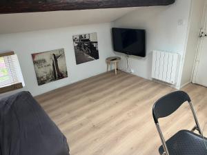 a living room with a flat screen tv on the wall at La Tour Ronde in Grézieu-la-Varenne