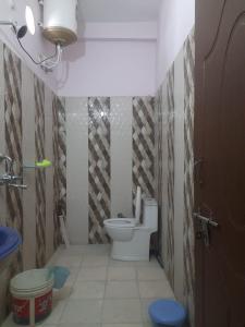 a small bathroom with a toilet in a room at Mangalam Palace in Uttarkāshi