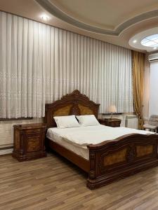 a bedroom with a bed and two tables and curtains at MIMFRI PREMIUM guest house, hotel in Tashkent +42 photos