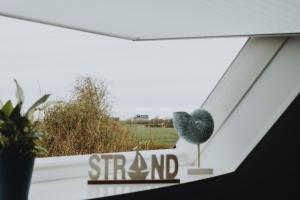a window with a sign that reads sing n at Küsten Auszeit in Wremen