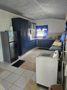 een keuken met blauwe kasten en een koelkast bij Bagatelle Terrace in Saint James