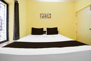 1 dormitorio con 1 cama blanca grande con almohadas negras en Hotel O SAHOO GUEST HOUSE, en Bhubaneshwar 22 fotos más