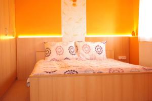 a bedroom with a bed with orange and yellow walls at Bors Apartman Szeged in Szeged