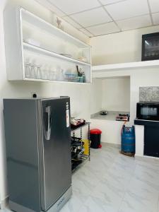 Una cocina con refrigerador de acero inoxidable en una habitación. en SunRest, en Weligama