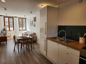 a kitchen and dining room with a table and a sink at Cour Saint Jean in Le Neubourg